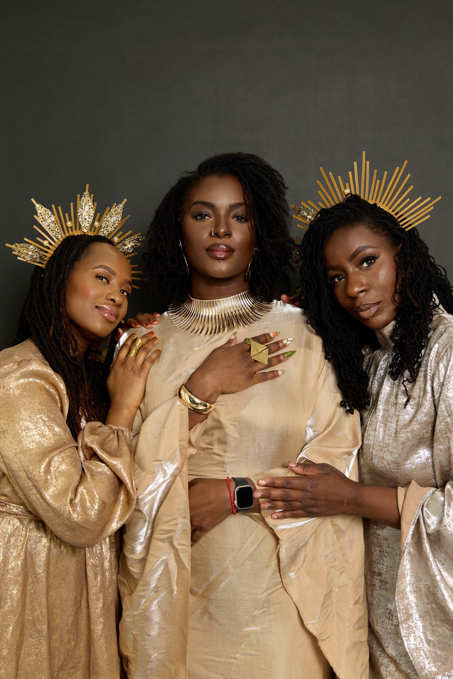 Trois femmes portant des locks et des couronnes dorées